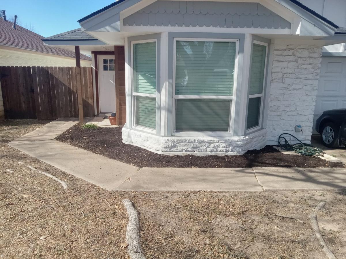 Fresh mulch bed installed along the front of a house